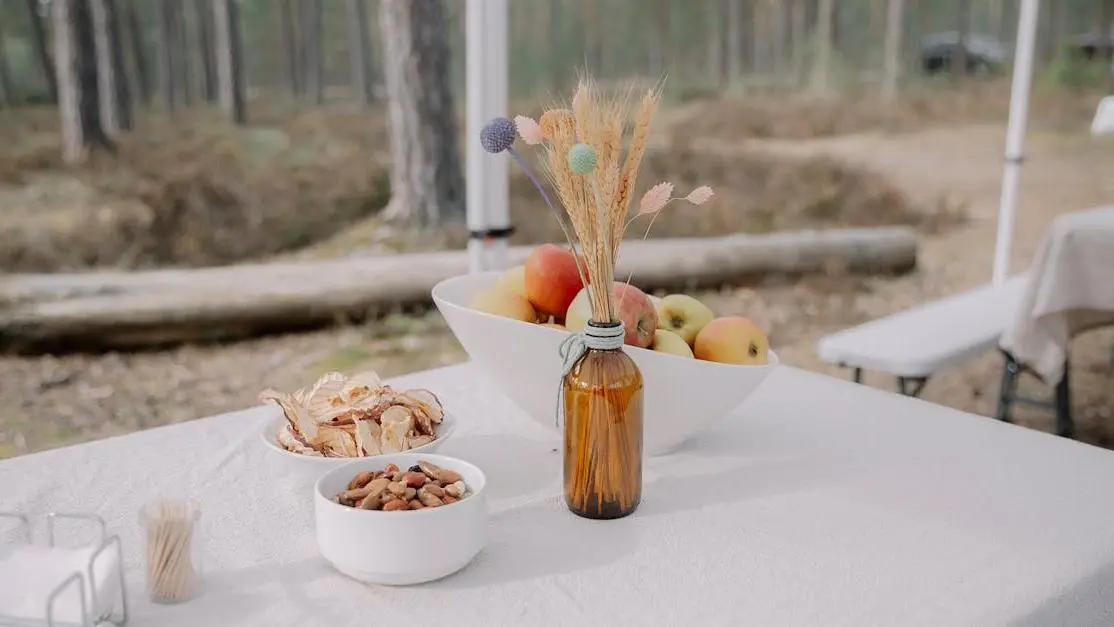 Rustic outdoor table with apples and snacks for meal planning for retreats in a forest setting.