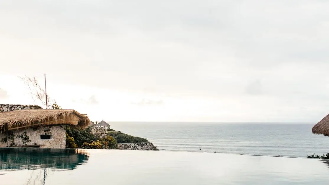Infinity pool with panoramic sea view, highlighting retreat amenities at tropical resort.