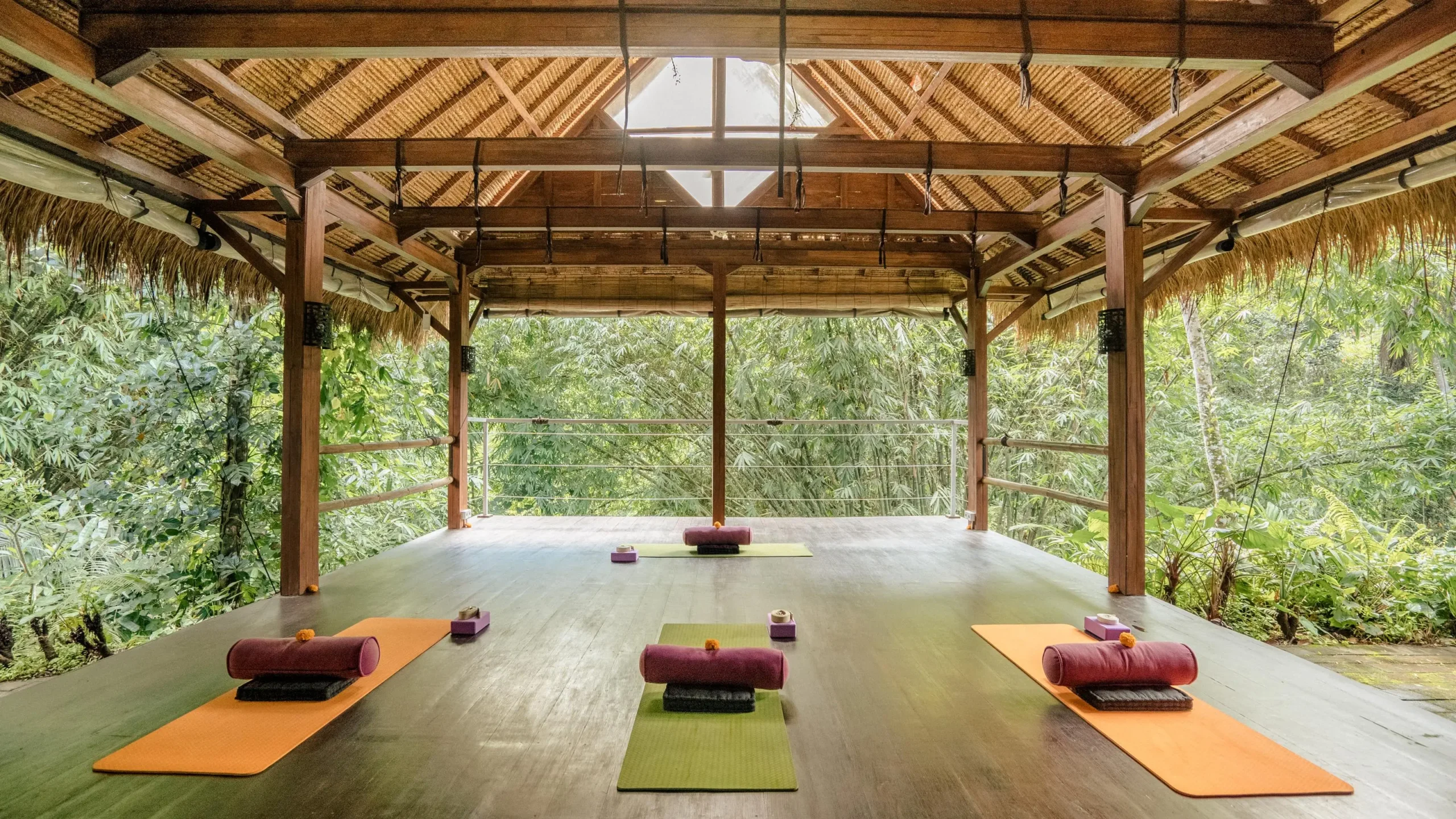 Yoga room with wooden floor and roof, set up for retreat program schedule activities