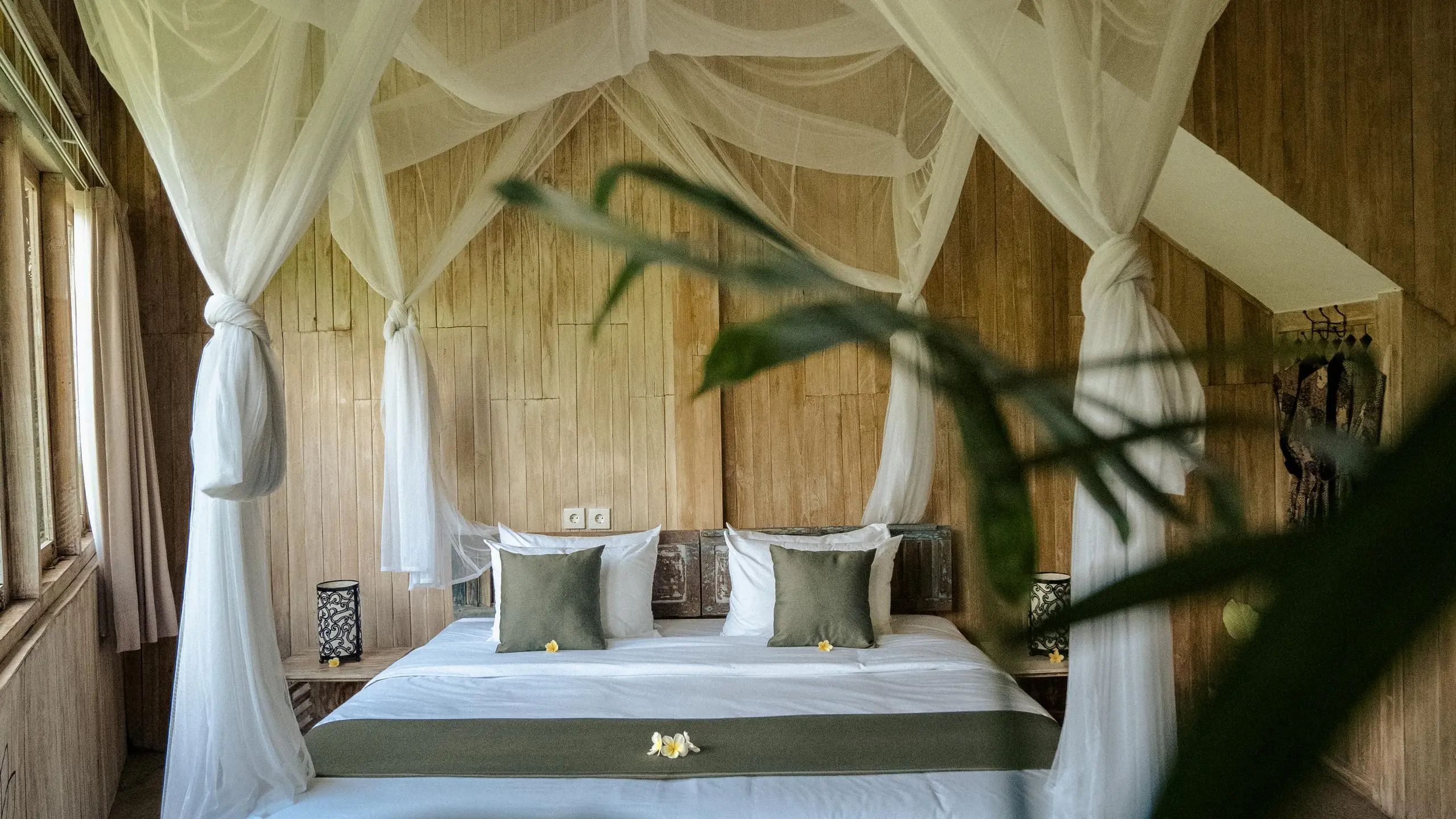Serene bedroom with white canopy bed at an affordable Bali retreat