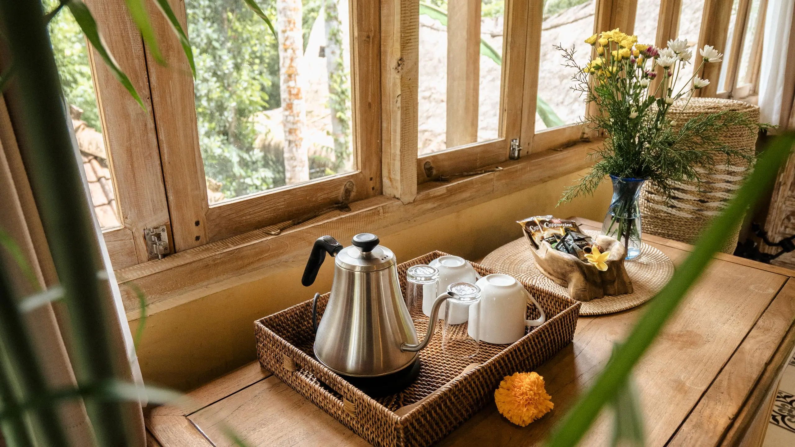 Basket of local food on wooden table with smartphone displaying Bali travel apps