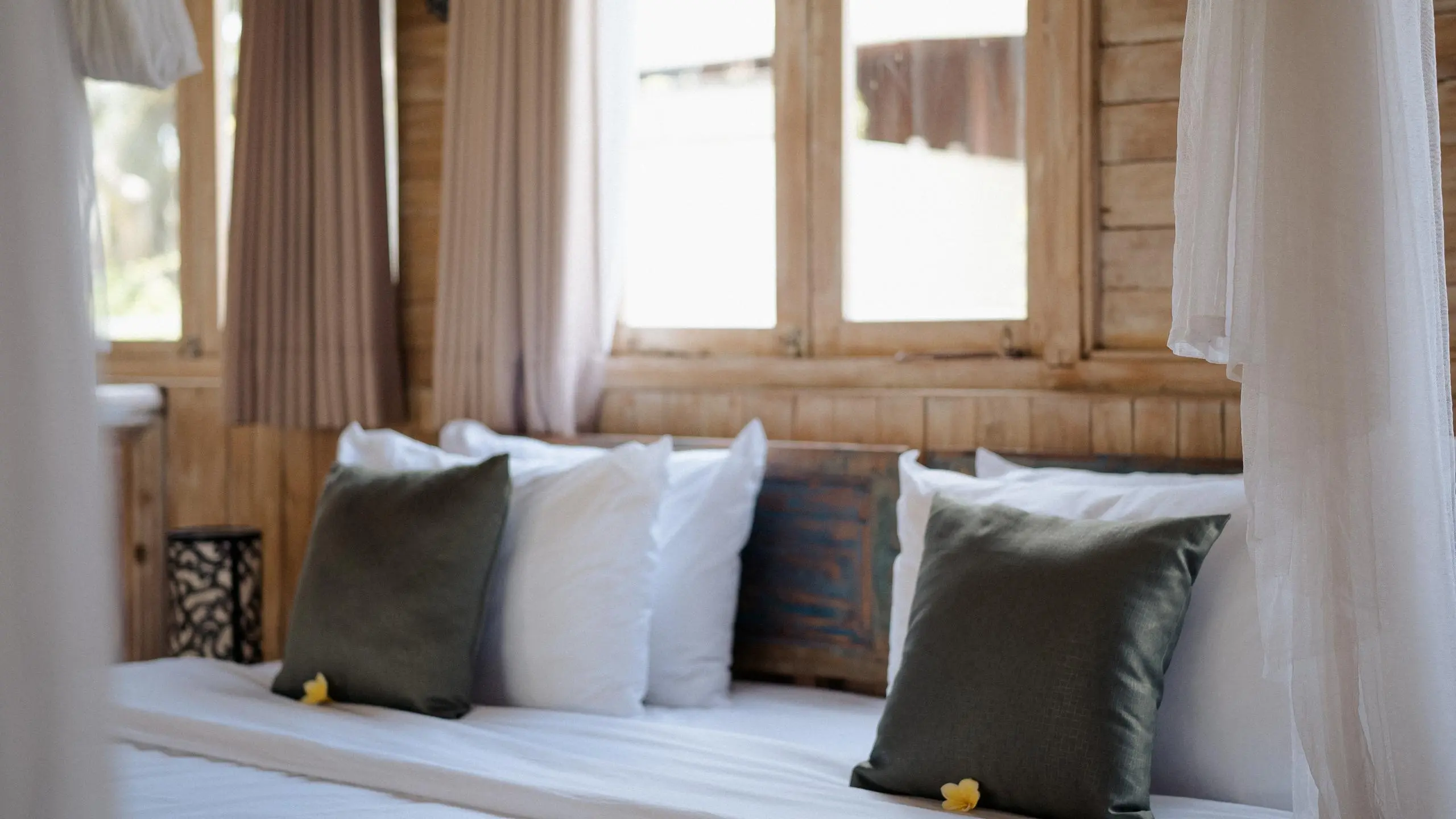 best travel yoga mat rolled out on a bed with a canopy in a cozy, travel-friendly room