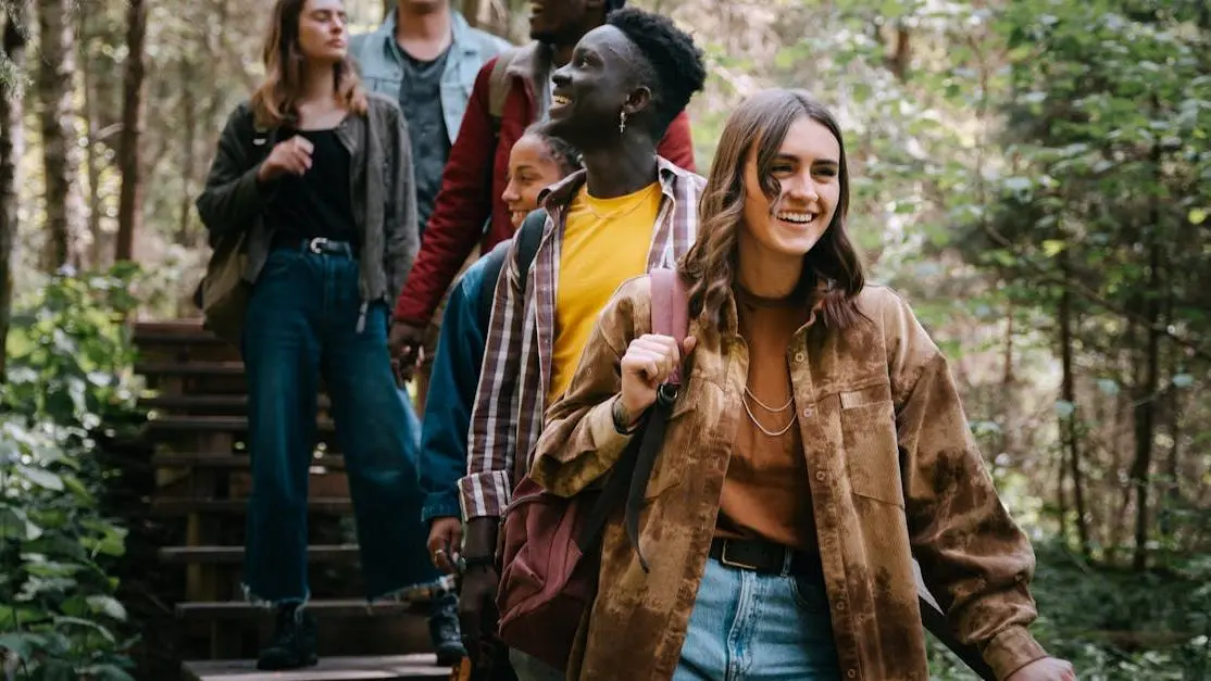 Group hiking on forest trail practicing eco friendly travel tips