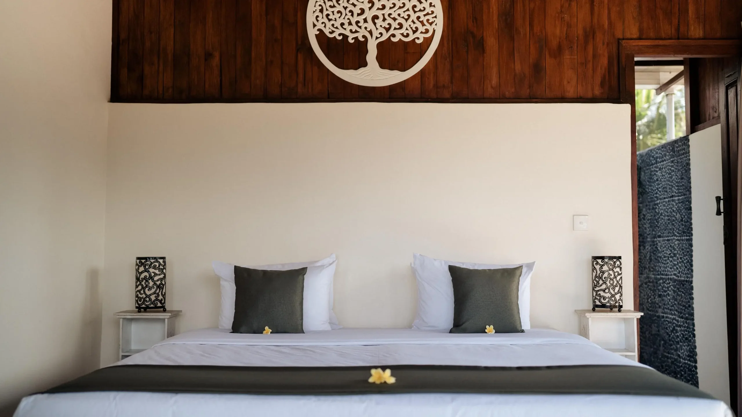 Minimalist travel packing: neatly folded clothes on a white bed with simple decor and wall art