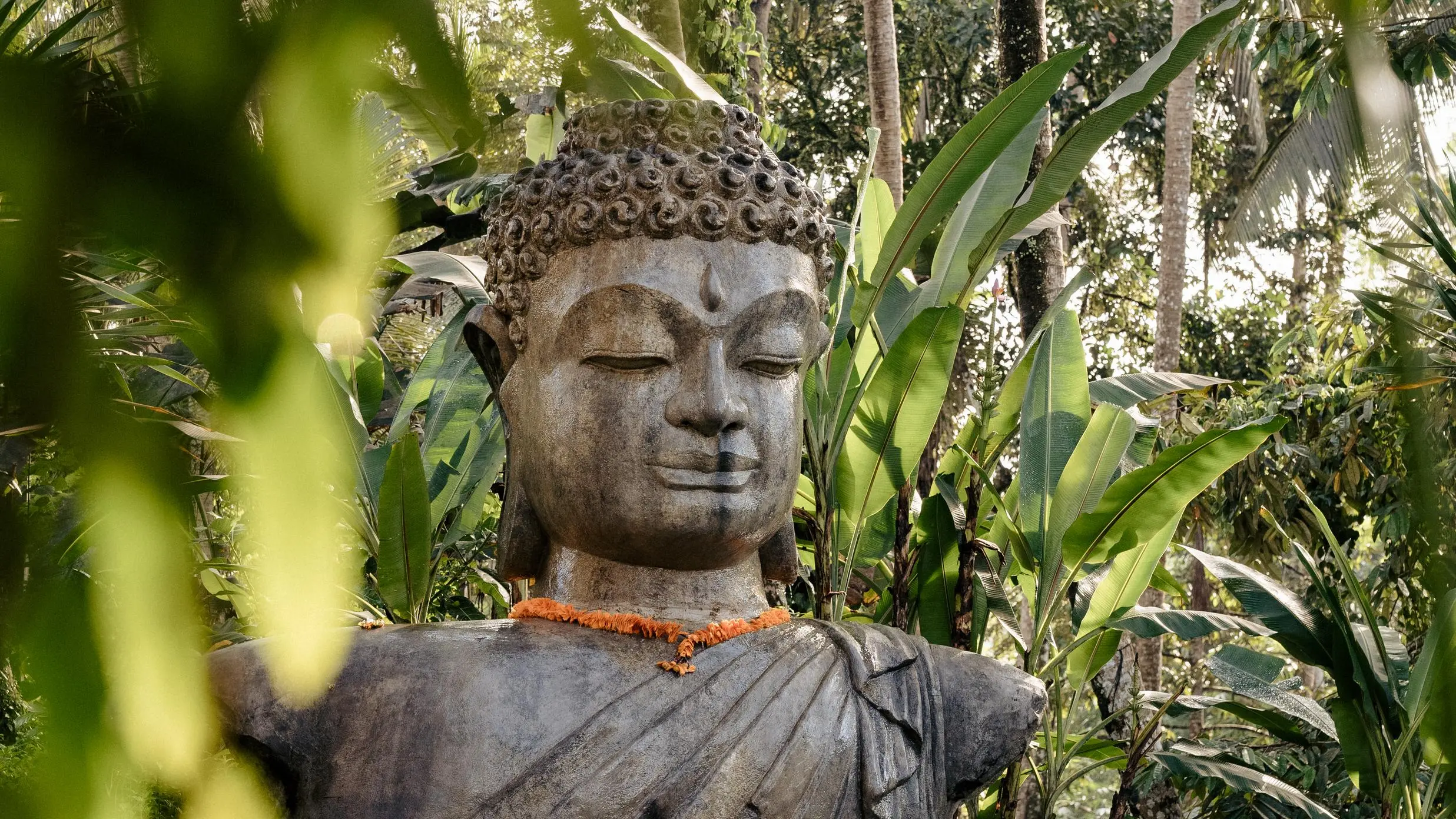 Serene garden statue in reflective pool, evoking calm and sound bath benefits for relaxation