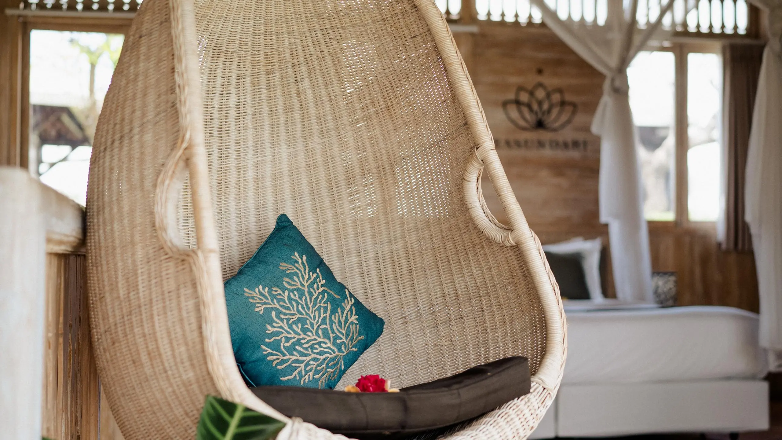 Hanging chair with cushion on balcony surrounded by eco-friendly amenities in Bali